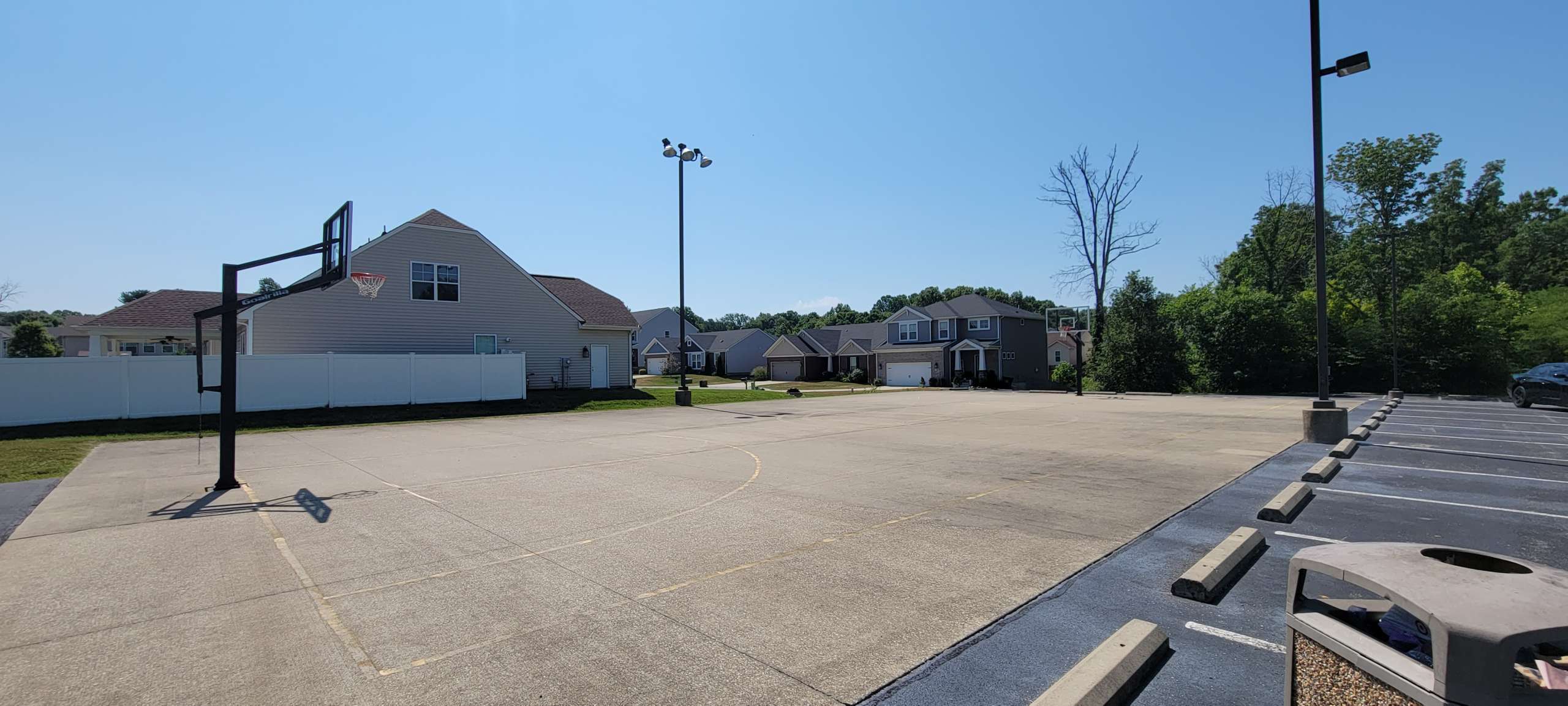 a parking lot with houses and trees in the background