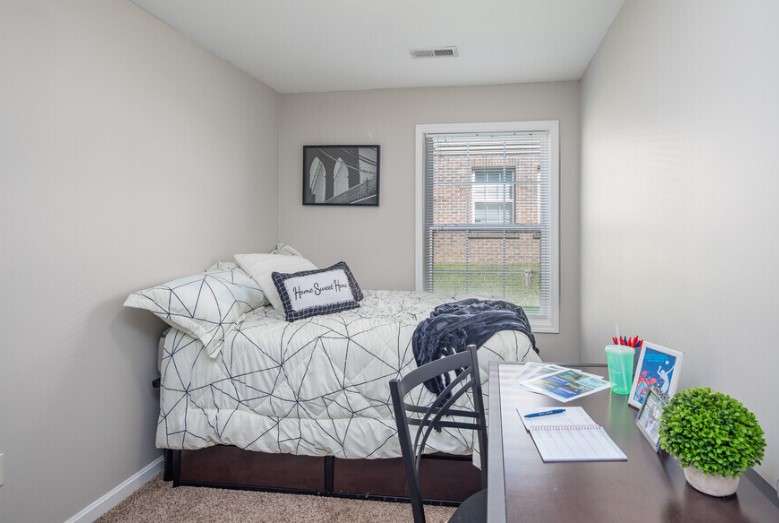 a bedroom with a bed and desk