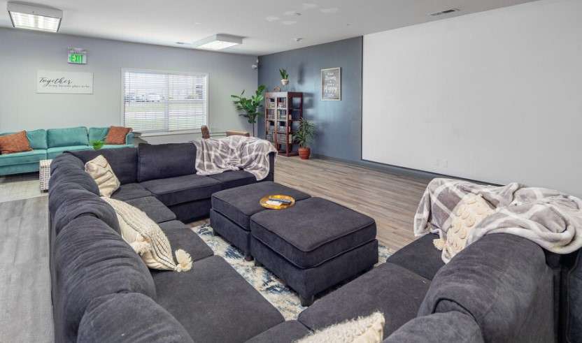 a living room with a large couch and a white board