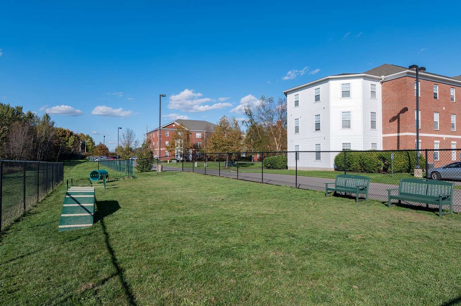 a dog park with a fence and a building