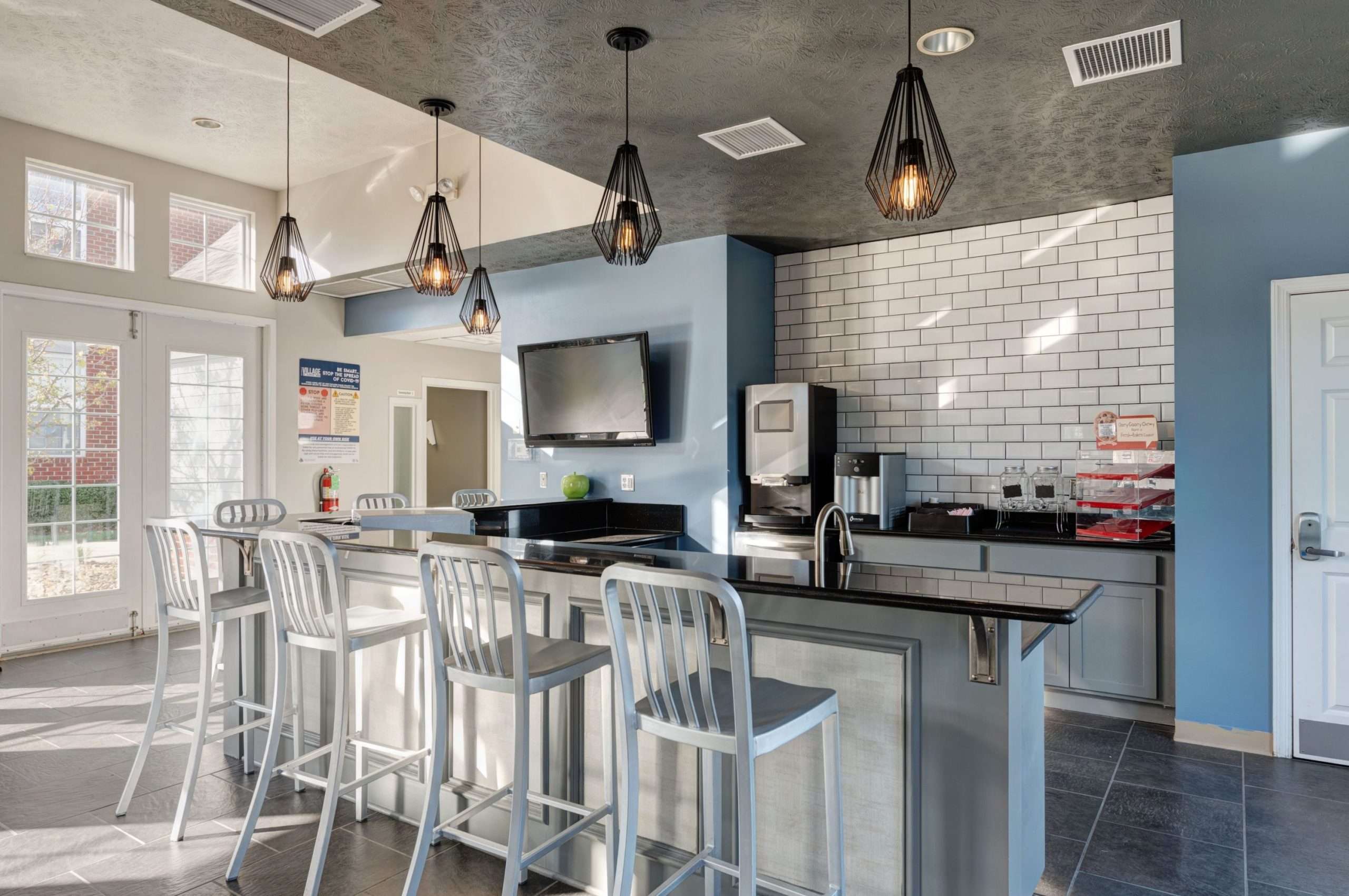 a kitchen with a bar and a television