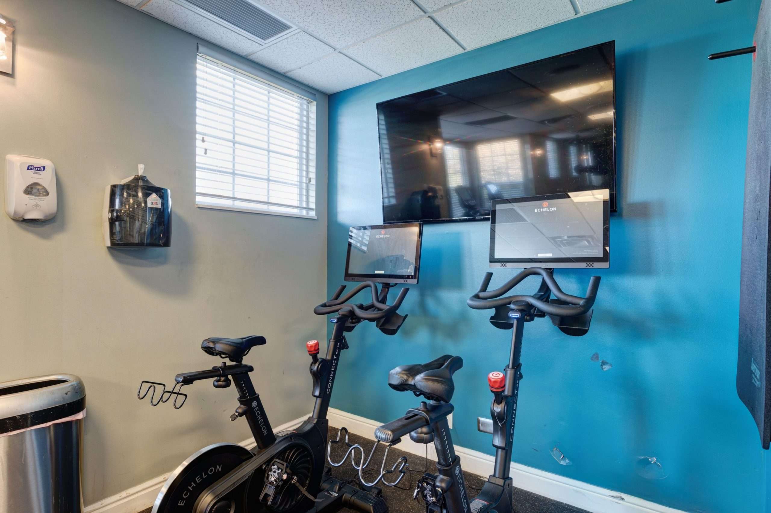 a room with exercise bikes and a tv on the wall