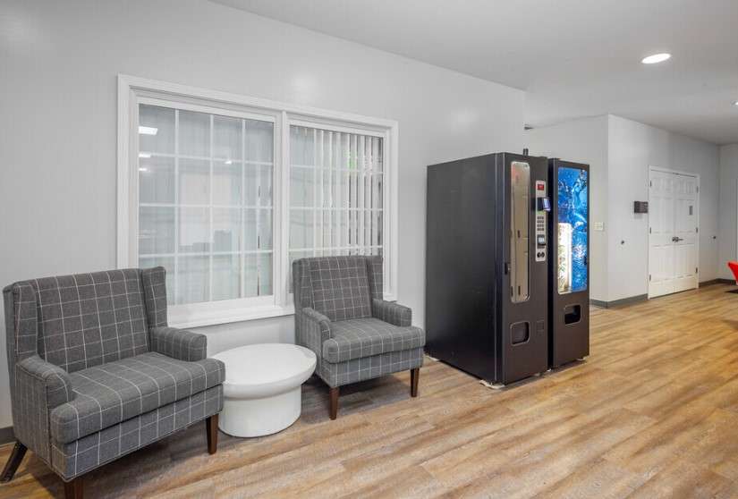 a room with two chairs and a vending machine