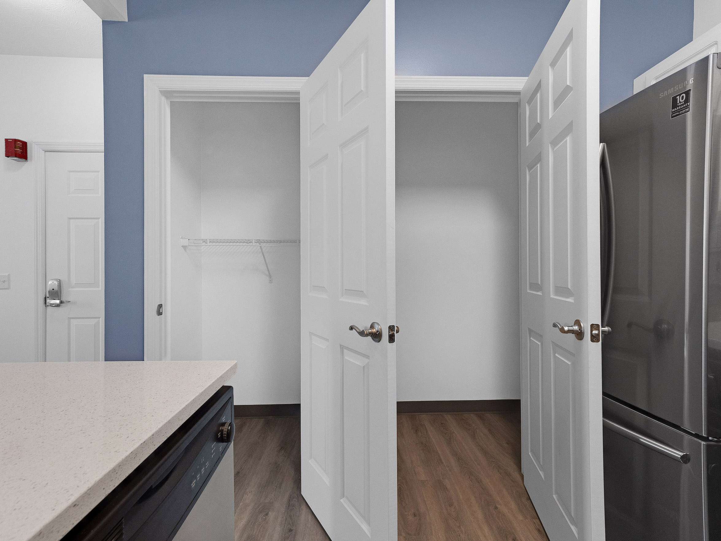 a room with white doors and a wood floor