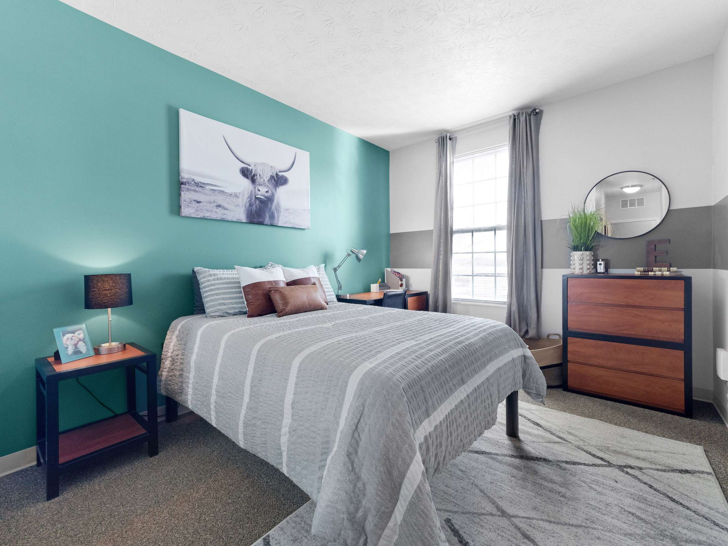 a bedroom with a bed and a painting on the wall